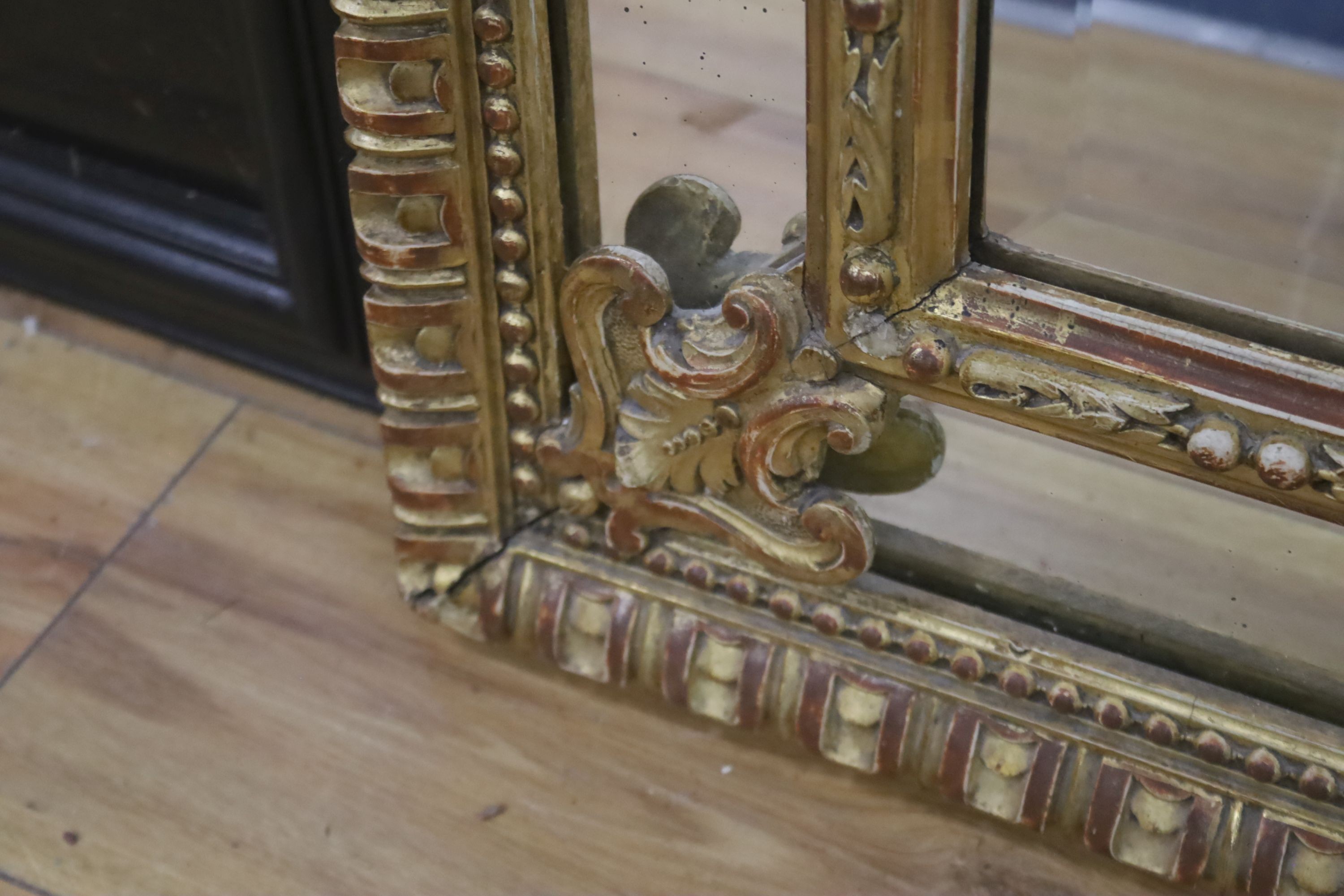 A 19th century giltwood and gesso overmantel mirror with Olympic Torch & Laurel Crown, side cushions with decorated bead detail, width 92cm, height 153cm